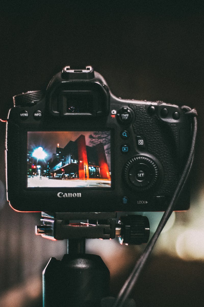 Close-up of a camera capturing a vibrant urban scene at night with a blurred bokeh background.